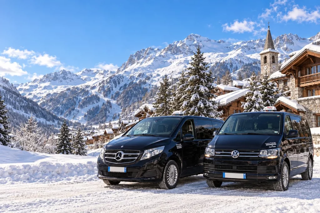 Vans noirs dans un village enneigé au pied des montagnes.